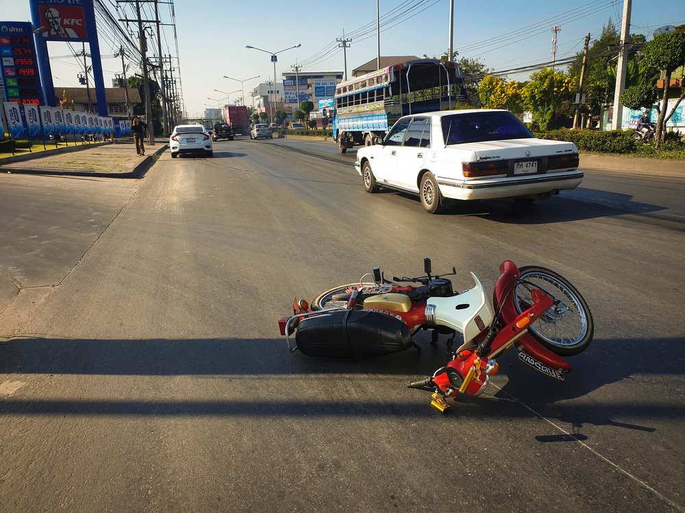 Motorcycle down in the road after a collision with a vehicle at an intersection