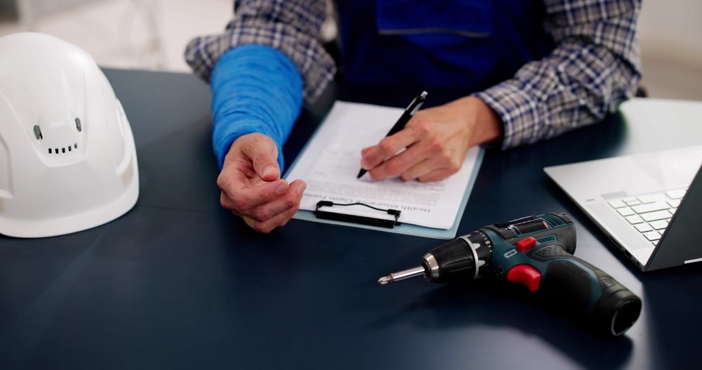 Injured construction worker signing a health insurance claim form in Columbus