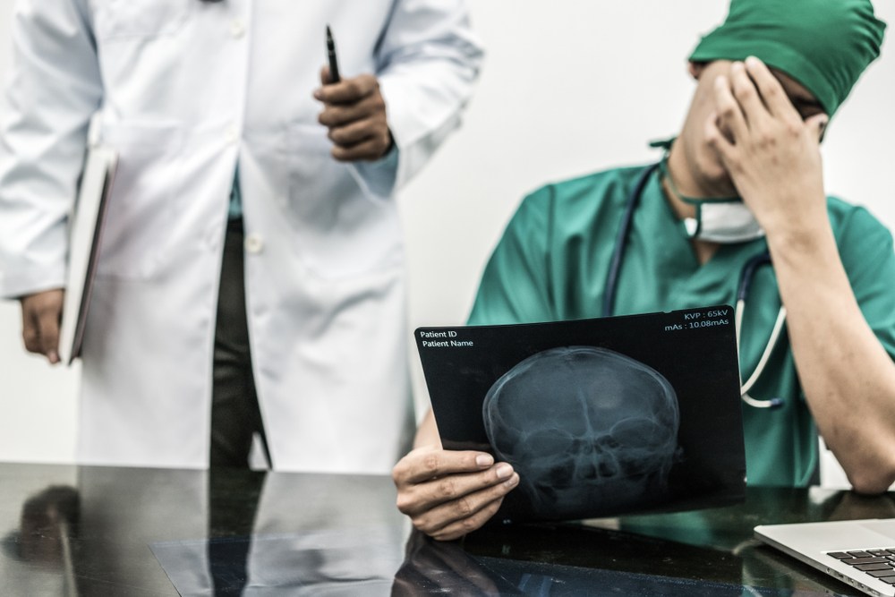 Surgeon reviewing a patient's X-ray for signs of a diagnostic error